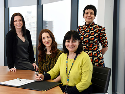 Signing the Memorandum of Understanding between Teesside University and Streetwise Opera. From left - Sarah O'Brien (Programme Leader in School of Computing, Engineering and Digital Technologies),  Ree Collins (Regional Programme Producer, Streetwise Opera), Professor Chrisina Jayne (Dean of the School of Computing, Engineering & Digital Technologies) and Siobhan Fenton (Associate Dean of the School of Computing, Engineering & Digital Technologies).. Link to View the pictures.