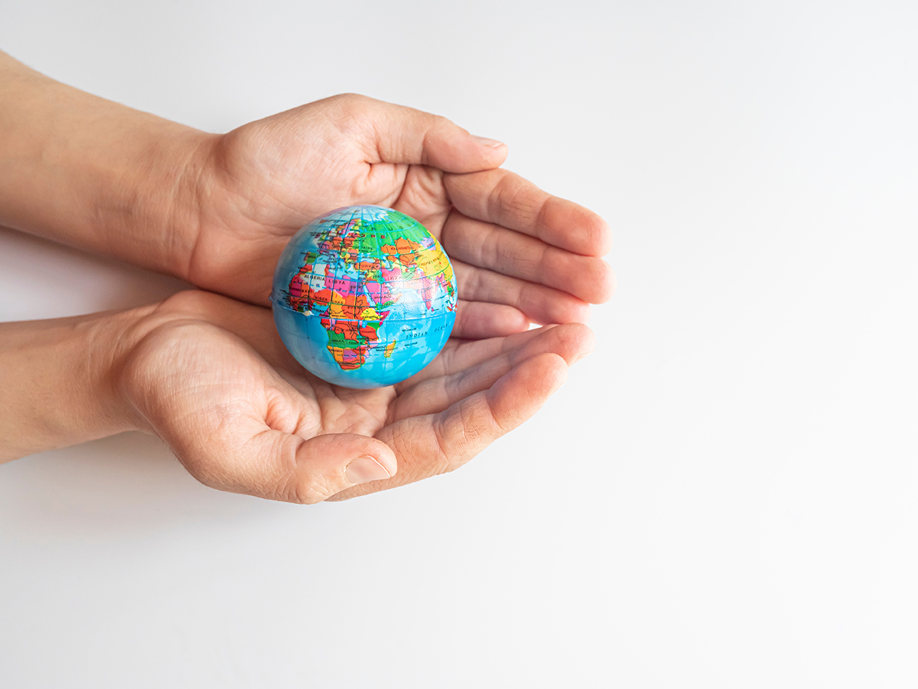 Cupped hands, palms upwards, holding a globe.. Link to TU Global Opportunities Week 2024.