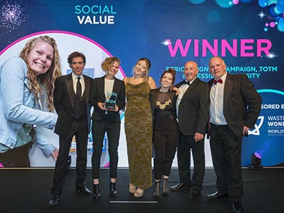 Actor Stephen Mangan, who hosted the IWFM Impact Awards event, pictured with Vik Brown holding the award, and representatives from TOTM and IWFM . Link to Partnership addresses period poverty.