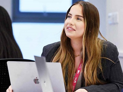 Woman on laptop. Link to New alumni benefit - access professional recruitment support.